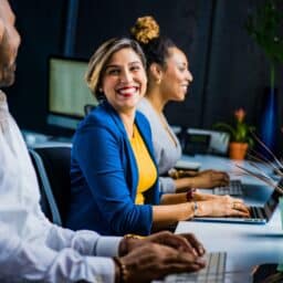 Woman at a new job smiling and talking with her coworkers.